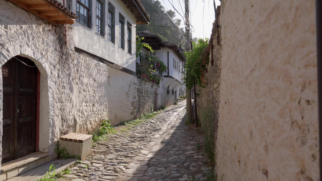Stretto vicolo acciottolato con tradizionali case in pietra imbiancate a calce, città UNESCO Berat, Albania