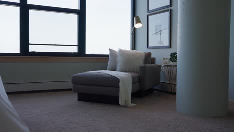 urban loft bedroom with serene grey lounge chair: cozy, modern, and stylish city living with a peaceful vibe