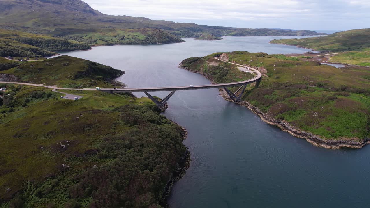 A breathtaking aerial view of the Kylesku Bridge in Scotland surrounded by hills and water