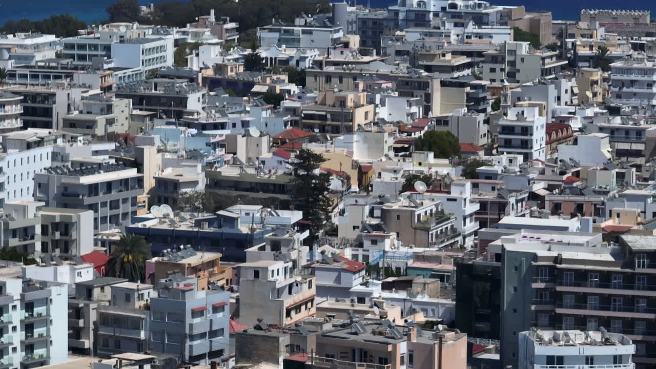 Telephoto drone shot of modern buildings in Rhodes city, sunny day in Greece
