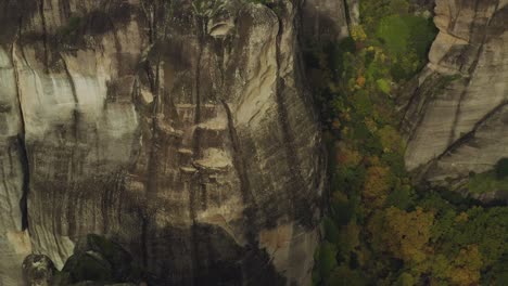 aerial view over cliffs, revealing the great meteoron monastery, in sunny meteora, greece - tilt, drone shot - the holy monastery of the transfiguration