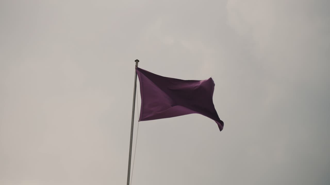 bandera púrpura balanceándose con el viento durante la semana santa en antigua guatemala - ángulo bajo
