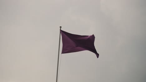 purple flag swaying with the wind during holy week in antigua guatemala - low angle