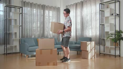 man moving boxes in living room