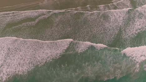 top down aerial drone view of waves coming in to the beach