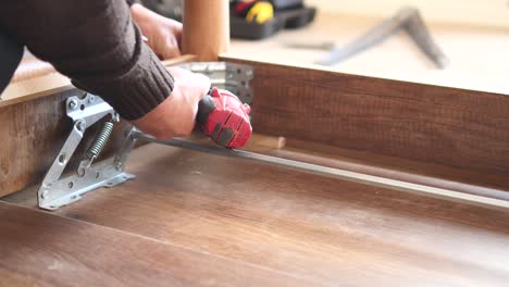 person assembling a table with a drill