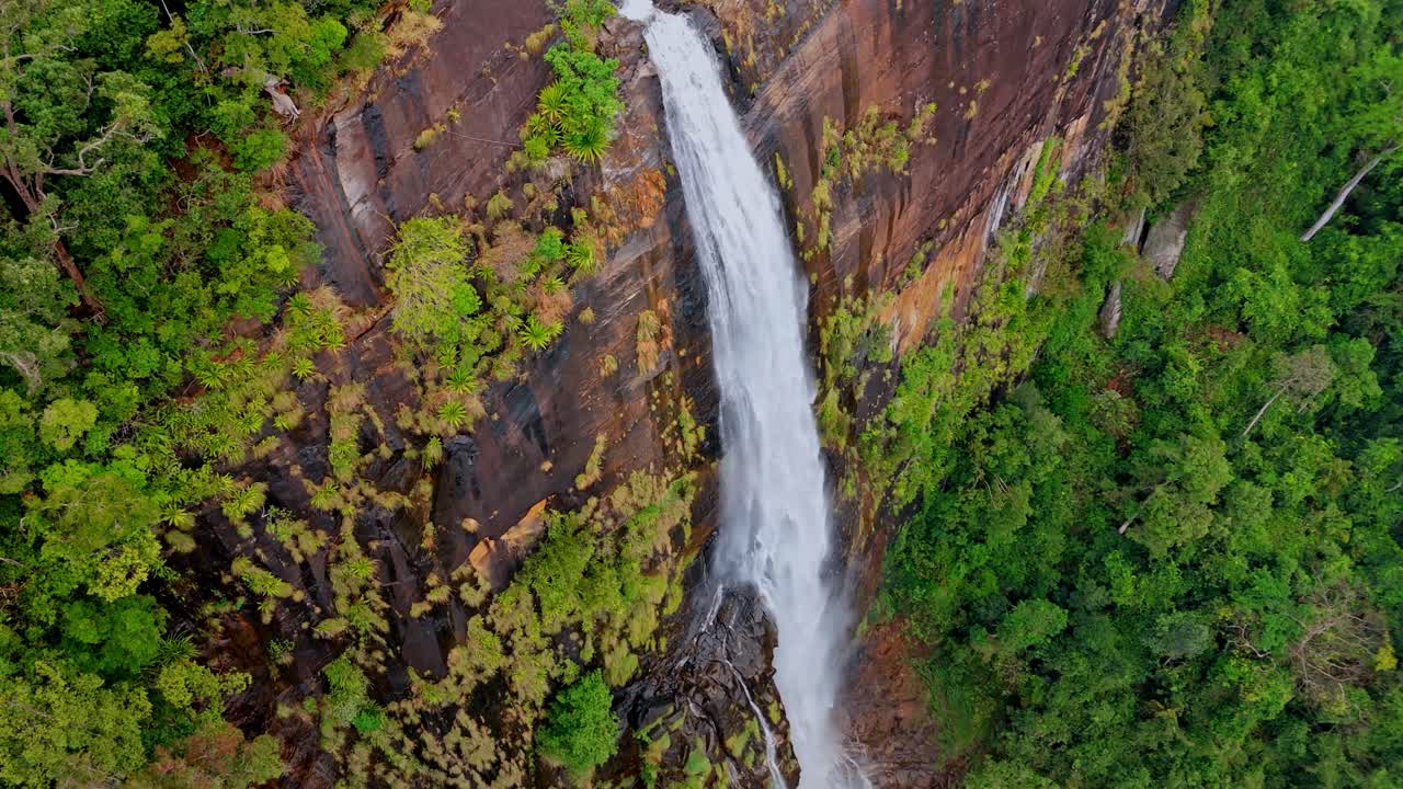 Experience the mystical allure of Diyaluma Falls as captured by aerial drone footage on a foggy day.