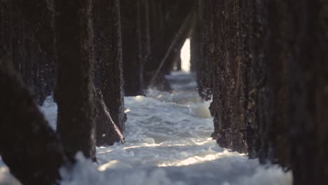 Waves-crashing-under-a-pier,-during-a-storm