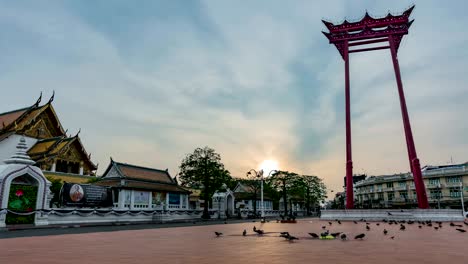 4k cinemagraph, "wat suthat thepwararam" the top of famous ancient temple in bangkok, thailand technique timelape at the sky with sunset behind movement cloudy. and the one signature is a big giant swing in front of temple. in 2005, the giant swing, toget