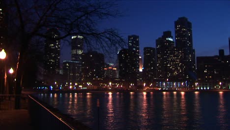 the chicago skyline after dark with lights reflected in lake michigan