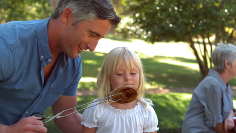 happy father doing barbecue with her daughter
