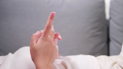 스마트 폰을 사용하고 들고 있는 젊은 여성의 손을 닫고, 터치스크린에서 위아래로 스크롤하고, 문자 메시지를 보냅니다.