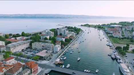 drone shot of river cetina bridge in the town of omis surrounded by mountains and the adriatic sea, croatia