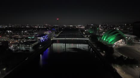 conference arena, river water reflections, illuminated buildings