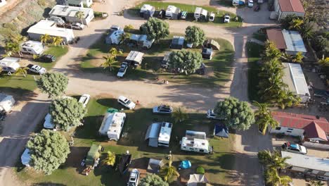 familia de 4k que llega al parque de caravanas al atardecer en tiempo de vacaciones toma aérea en cámara lenta 60fps