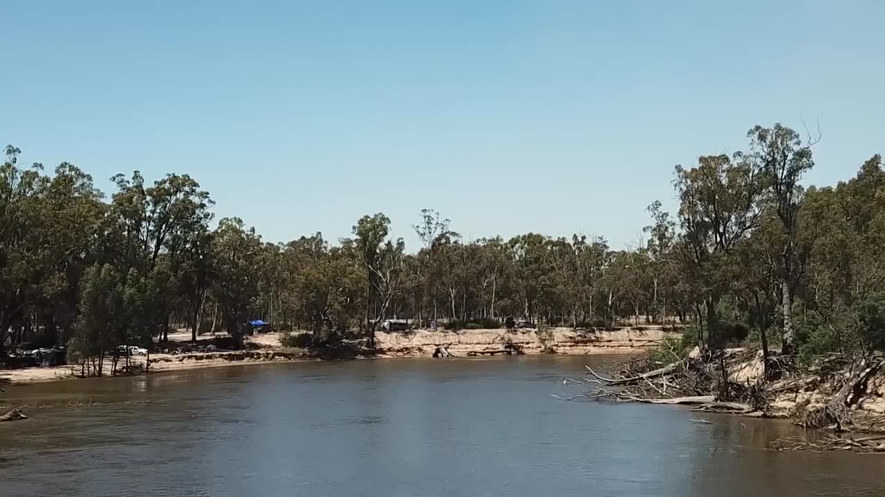 Vista aerea con drone di un fiume australiano fangoso, immerso nella natura.