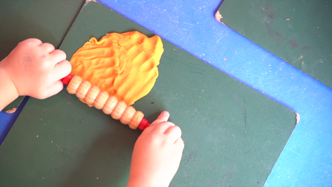 Crianças brincando com massinha de modelar em um tapete em uma escola Montessori