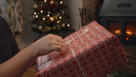 couple exchanging gifts in room decorated for christmas