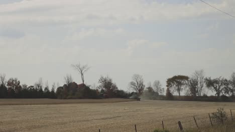 Landwirt-Auf-Mähdrescher-Erntet-Reife-Pflanzen-Auf-Einem-Staubigen-Feld