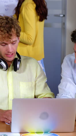 Group of business executives interacting over laptop