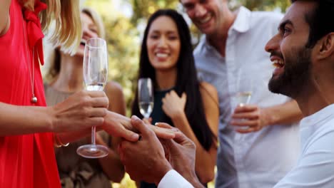 man putting a ring on a womans finger in balcony