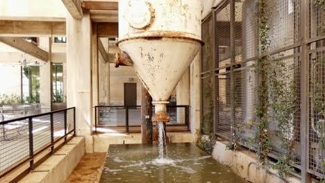 water gushing out of old rusty water tank drained for maintenance