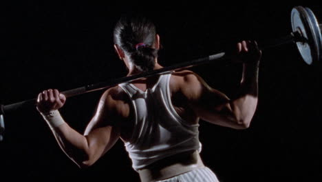 a man lifts barbells over his head to workout