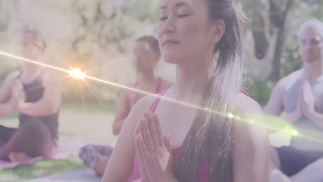 animation of light spots over diverse women practicing yoga and meditating