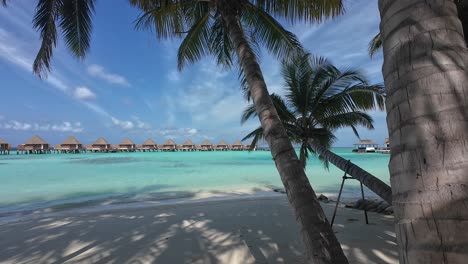 Aufnahme-Des-Strandes-Im-Kooddoo-Resort-Auf-Den-Malediven,-Zeigt-Klares-Wasser,-Das-An-Einen-Sandstrand-Plätschert