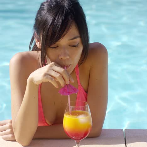 pretty young woman sipping a tropical cocktail