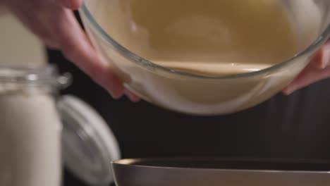 primer plano del hombre en la cocina de casa vertiendo la mezcla en lata para hornear pastel 1