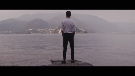 man standing on a pier overlooking a lake