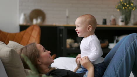 the best moments from life, a loving happy young mother hugs a nursing son, on a snow-white blanket, on a white background. concept of love, family, and happiness concept: children, kids, baby, babies