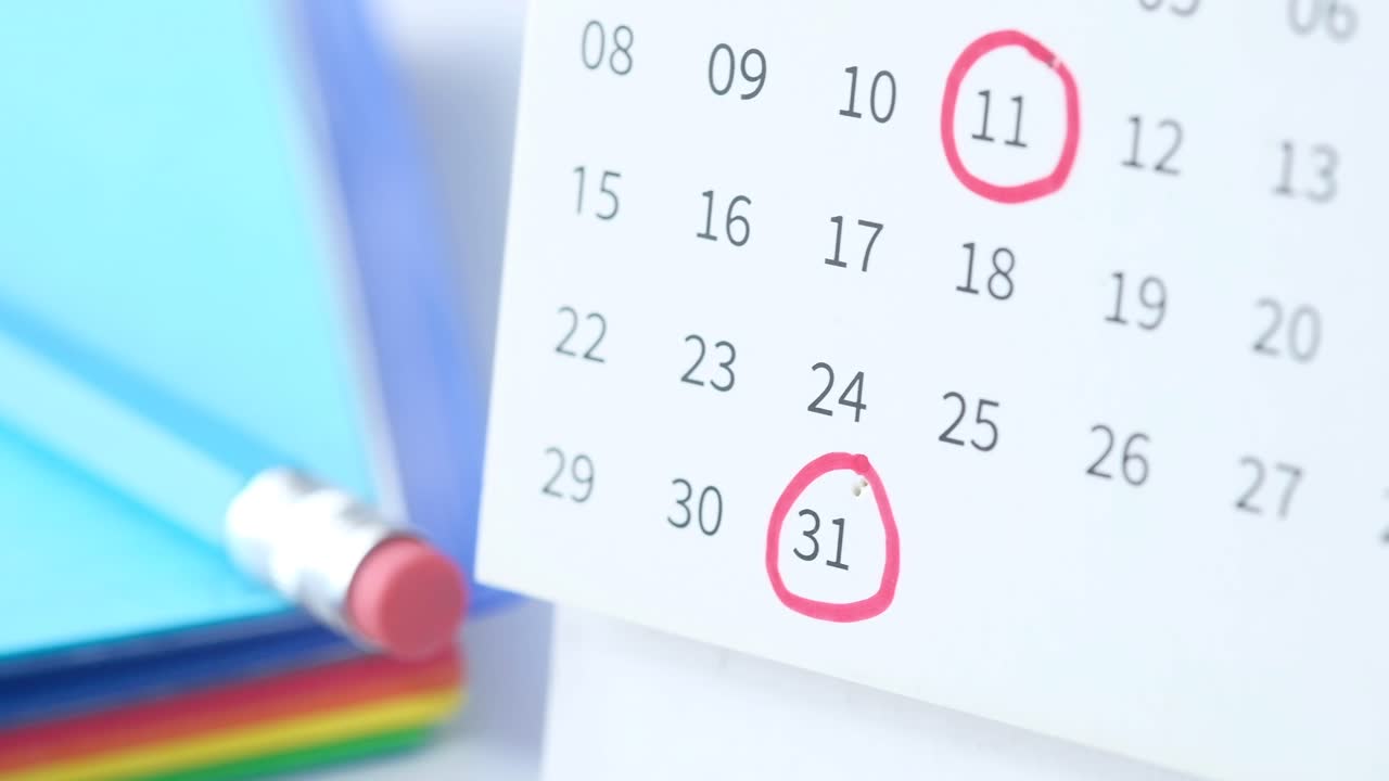 날짜와 사무실 용품을 둘러싸고 있는 달력의 클로즈업