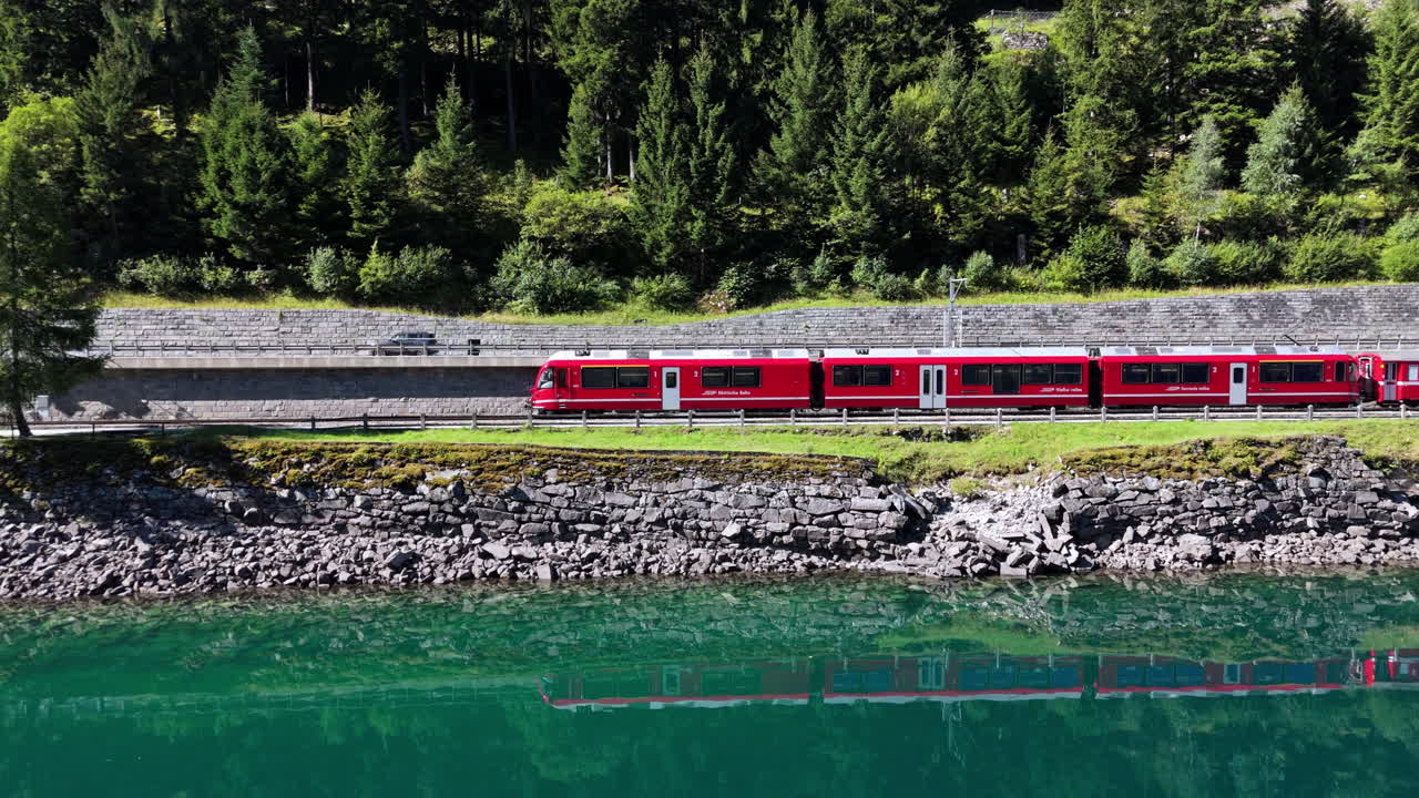 Red Train Reflecting in a Lake Amidst a Forest Landscape