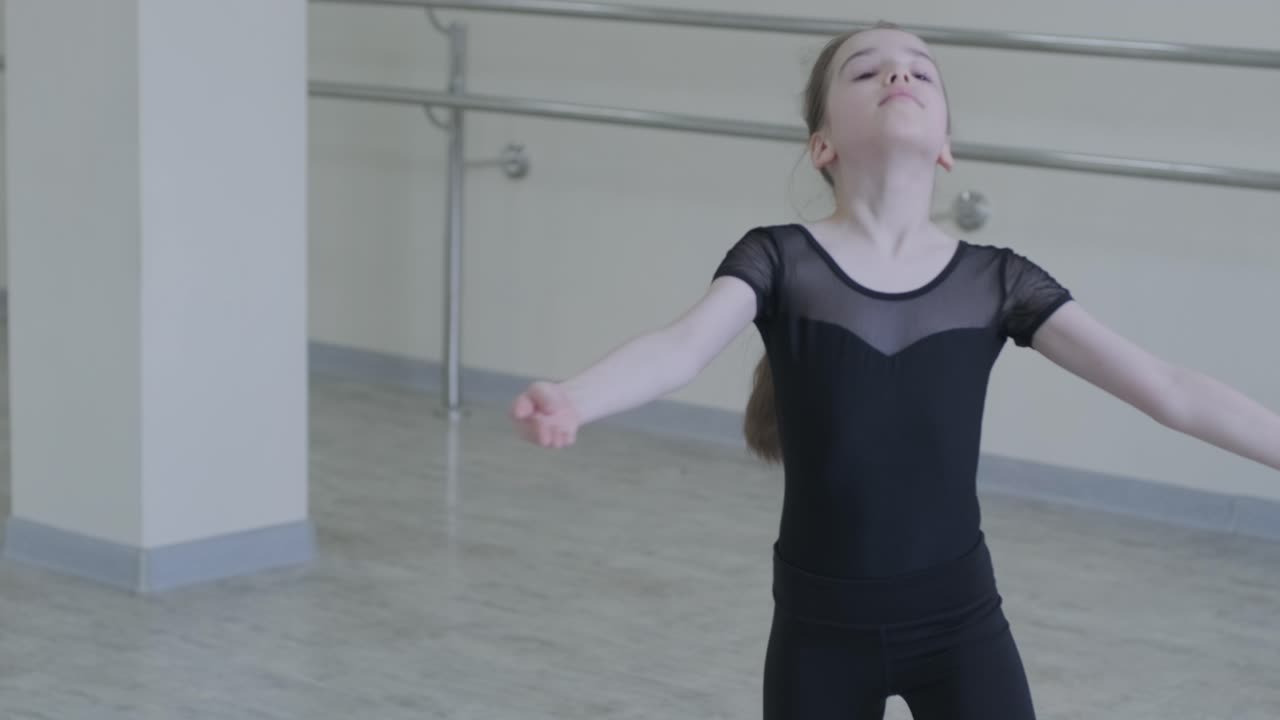Young Ballerina Practicing Dance Moves in Studio