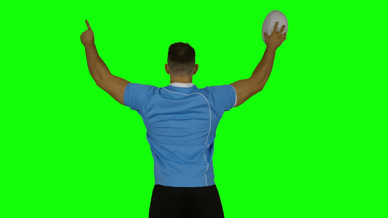 심각한 럭비 선수가 공으로 환호하고 있습니다.