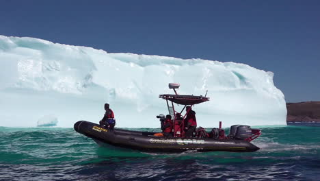 investigadores en un bote zodiac pasan un iceberg masivo en el ártico 1