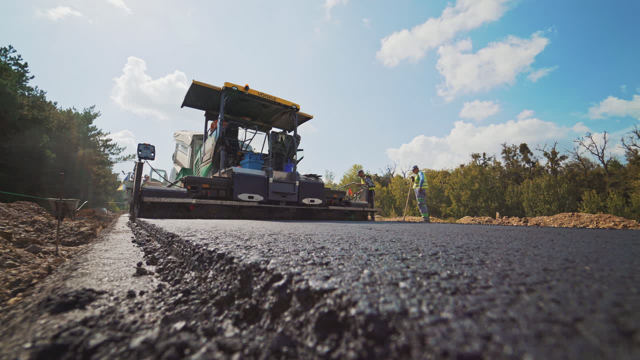 Countryside asphalt repair. Constructing asphalt road, construction with steamroller
