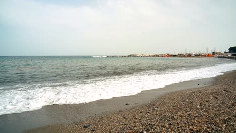 ligurian beach formed by pebbles, seen from below where the waves break on the pebble beach, varazze, liguria italy