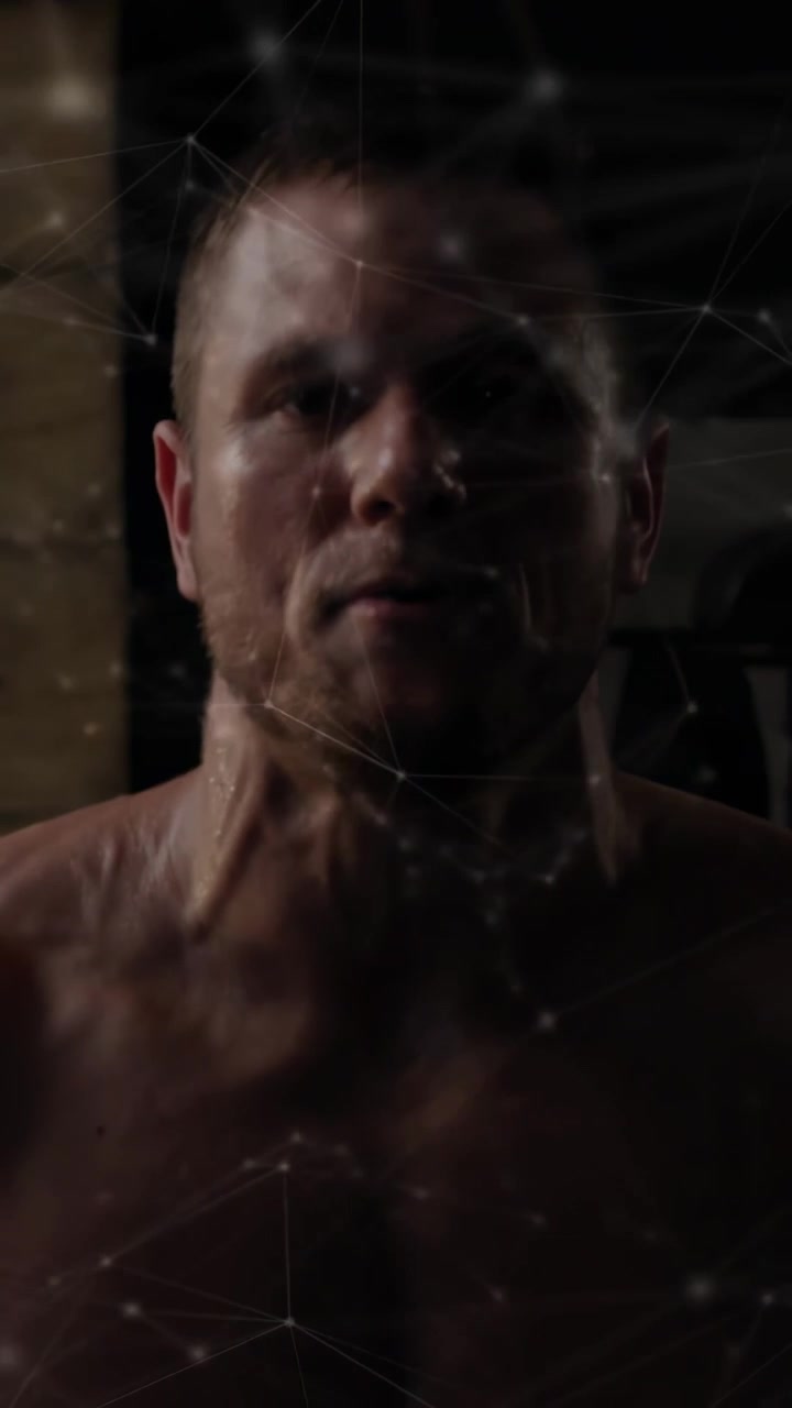 Video verticale: Uomo che inizia a sollevare pesi su una panca da palestra per il fitness, con una sovrapposizione a rete davanti.