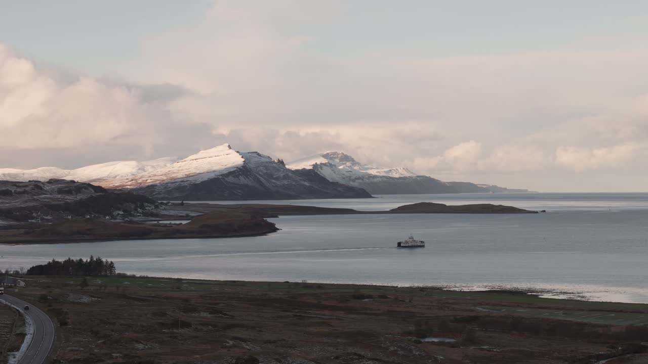 Stunning view of Scotland's mountains overlooking the sea, combining rugged highland terrain with sweeping coastal vistas. The landscape features dramatic peaks, hills, and the glistening water below