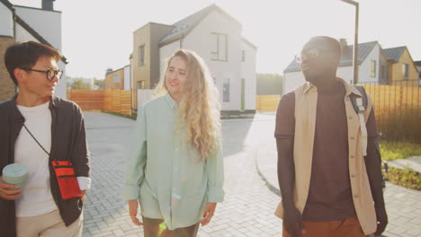 multiethnic man and women walking on street and speaking