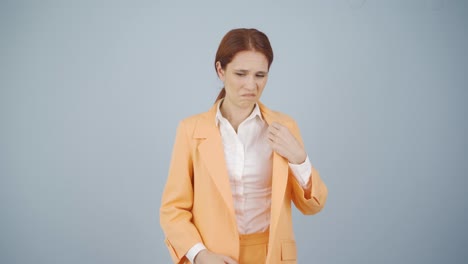 mujer de negocios oliendo sudor expresando negatividad en la cámara.
