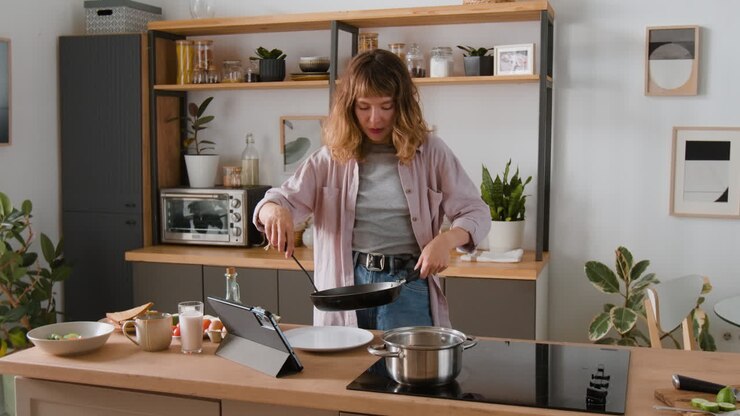 Donna che cucina le uova in cucina