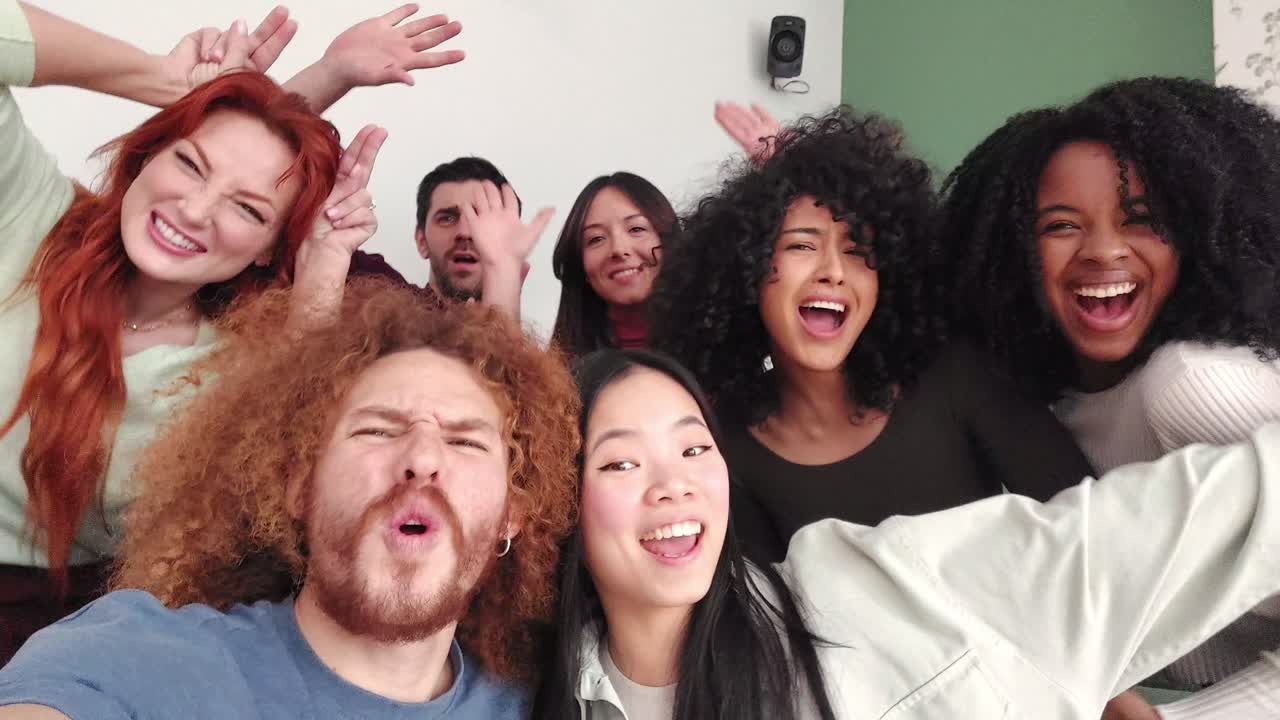 Multiethnic friends joking taking a selfie together at home