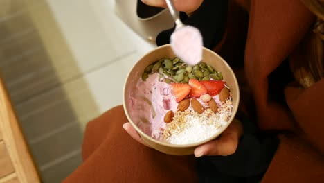 una mujer comiendo un delicioso yogur parfait.