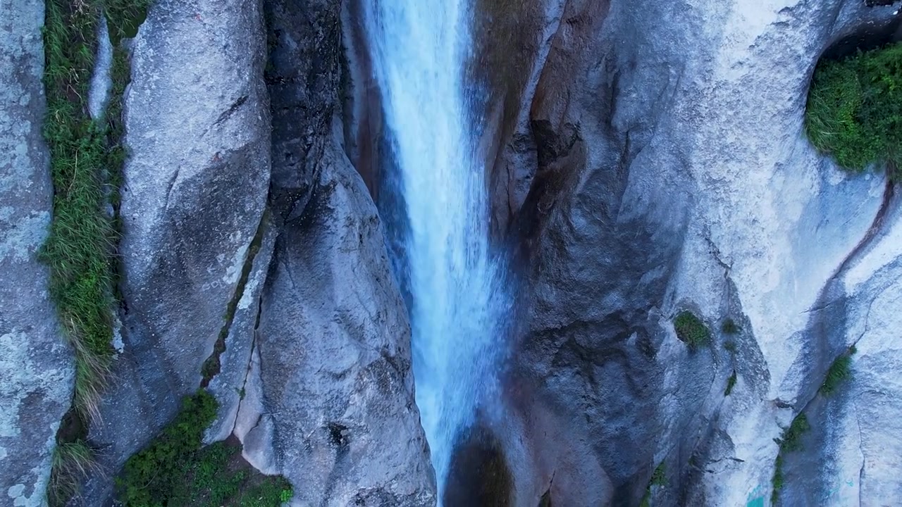 L'acqua scende a cascata attraverso uno stretto canyon roccioso in un primo piano di paesaggio naturale