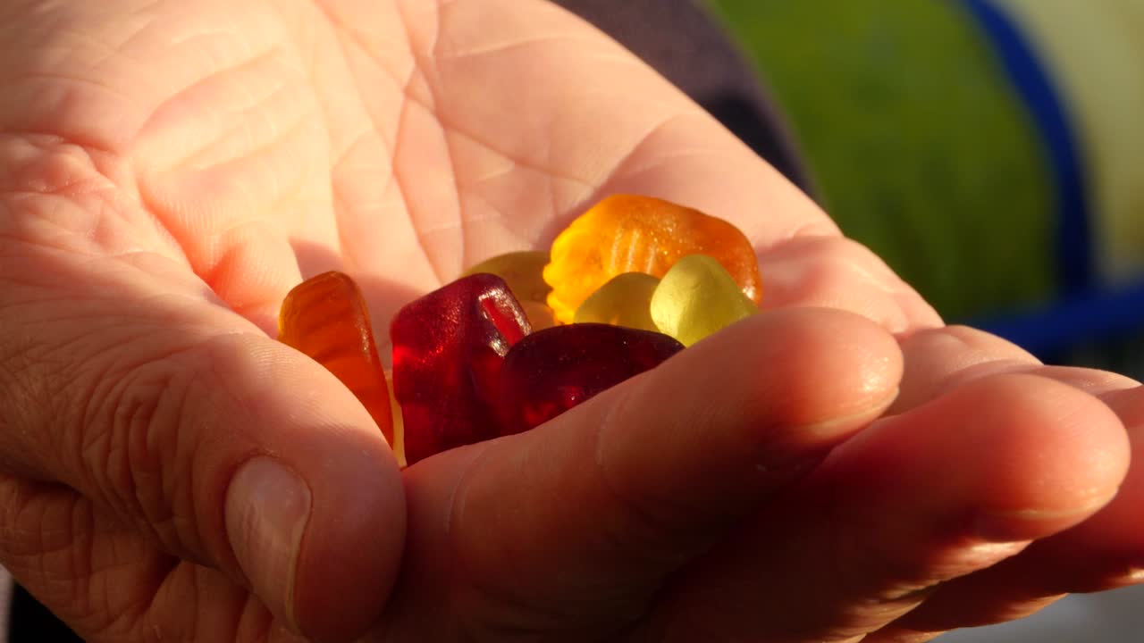 eating gummi bears out of a hand