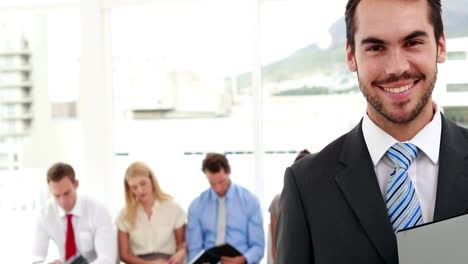 interviewer smiling at camera in front of applicants